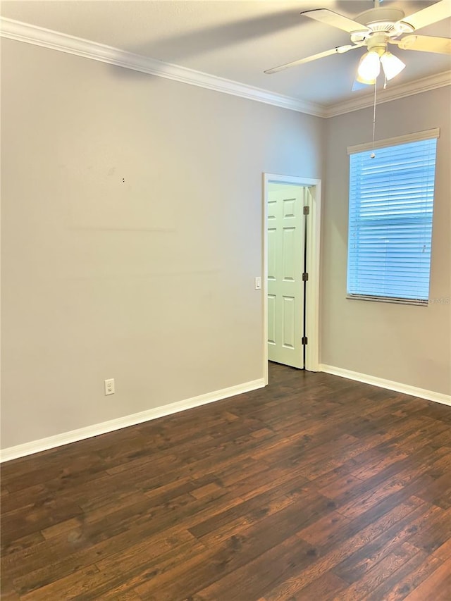 spare room with a ceiling fan, dark wood finished floors, crown molding, and baseboards