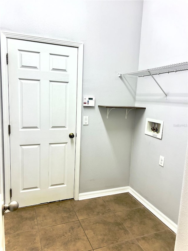 laundry room featuring dark tile patterned floors, laundry area, washer hookup, and baseboards