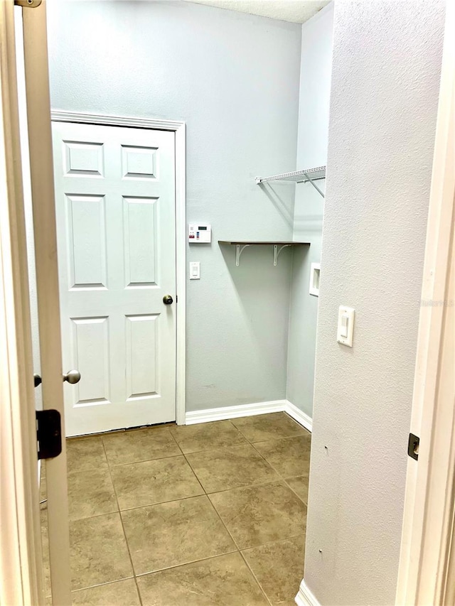 clothes washing area with washer hookup, laundry area, baseboards, and light tile patterned floors