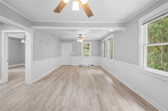 empty room with a wainscoted wall, light wood-style flooring, and ornamental molding