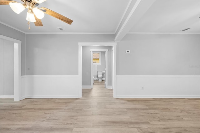 spare room featuring light wood-type flooring, visible vents, and crown molding