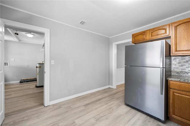 kitchen featuring visible vents, tasteful backsplash, light wood-style floors, and freestanding refrigerator