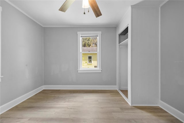 unfurnished bedroom featuring baseboards, ornamental molding, a ceiling fan, and light wood finished floors