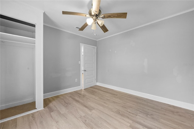 unfurnished bedroom with light wood-type flooring, crown molding, baseboards, and a ceiling fan