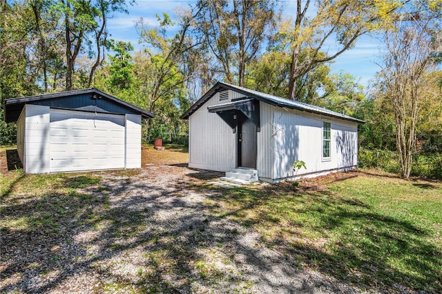 view of outbuilding featuring an outdoor structure, driveway, and entry steps