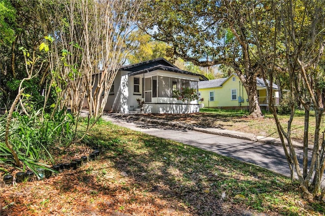 view of front of property featuring concrete driveway and a sunroom