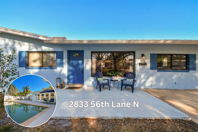 rear view of property with a patio area and an outdoor pool