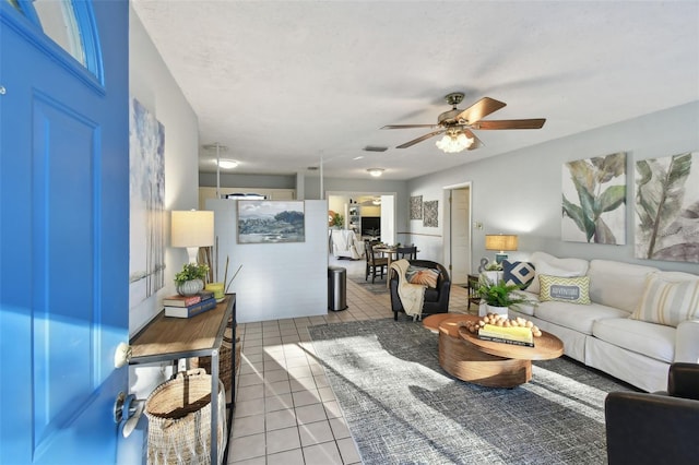 tiled living room with visible vents and ceiling fan