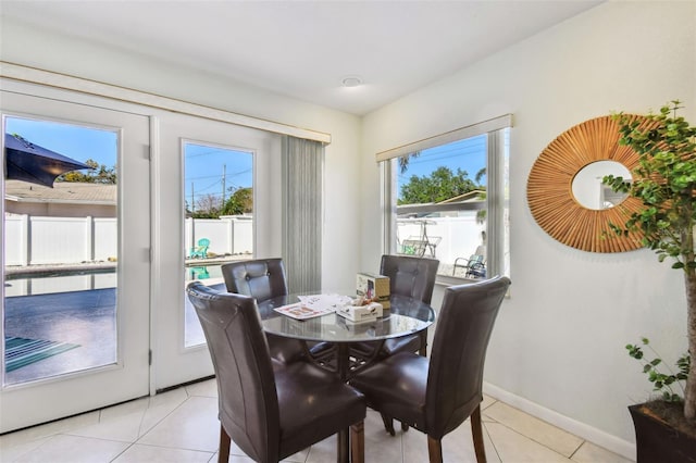 dining space featuring baseboards and light tile patterned flooring