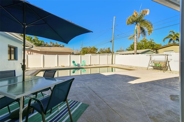 view of patio / terrace with a fenced in pool, a fenced backyard, and outdoor dining space