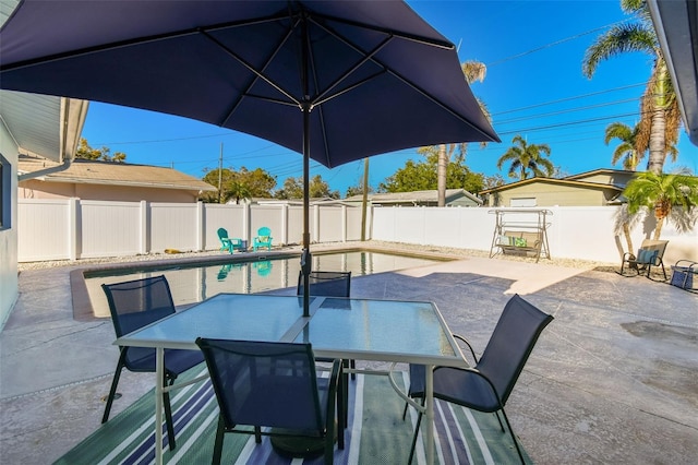 view of patio / terrace featuring outdoor dining space, a fenced in pool, and a fenced backyard