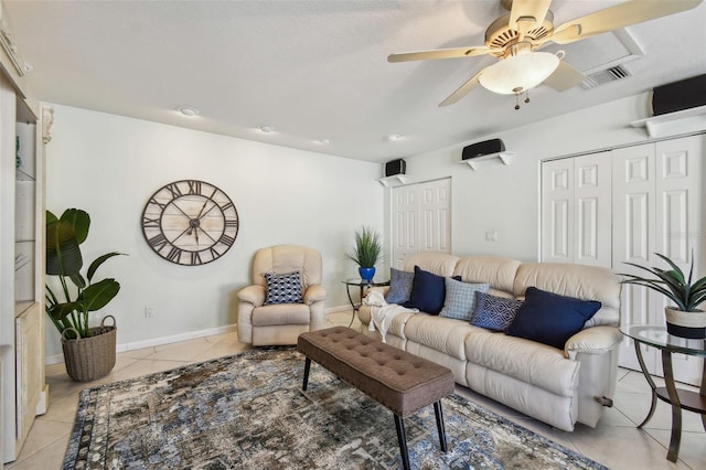 living area featuring ceiling fan, visible vents, baseboards, and light tile patterned flooring