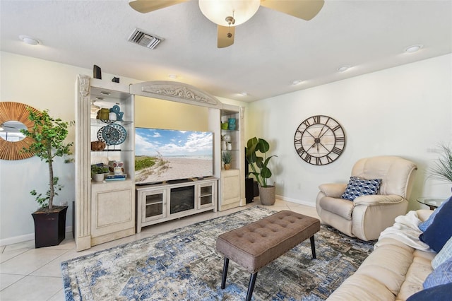 living area with light tile patterned floors, visible vents, baseboards, and ceiling fan