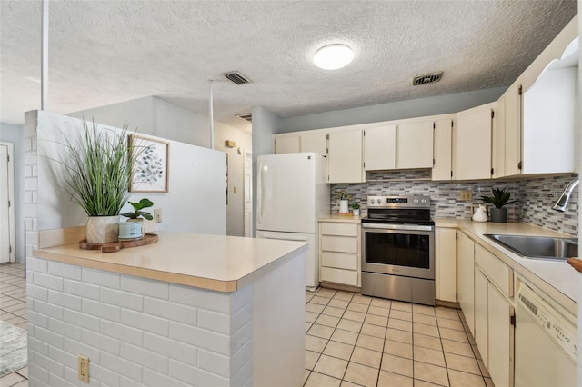 kitchen featuring visible vents, light countertops, decorative backsplash, white appliances, and a sink