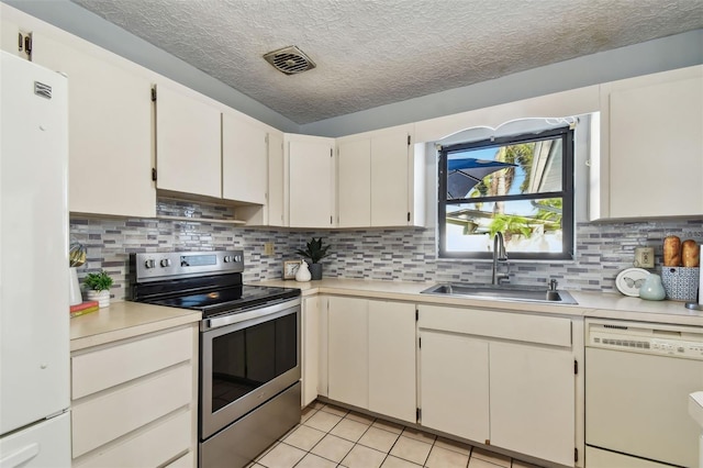 kitchen featuring a sink, white appliances, light tile patterned floors, and light countertops