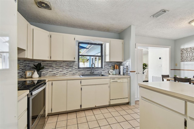 kitchen with a sink, dishwasher, light countertops, and stainless steel range with electric cooktop