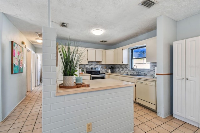 kitchen featuring visible vents, stainless steel electric stove, a sink, light countertops, and dishwasher