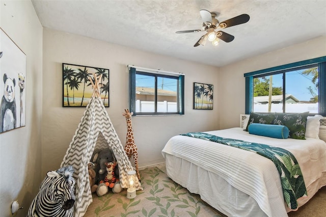 carpeted bedroom featuring baseboards and a ceiling fan