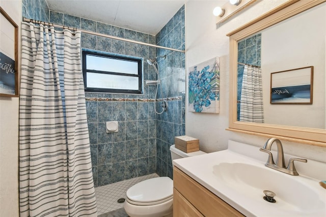 bathroom featuring toilet, tiled shower, and vanity