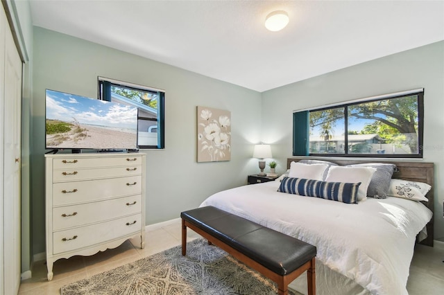 bedroom featuring light tile patterned flooring and baseboards