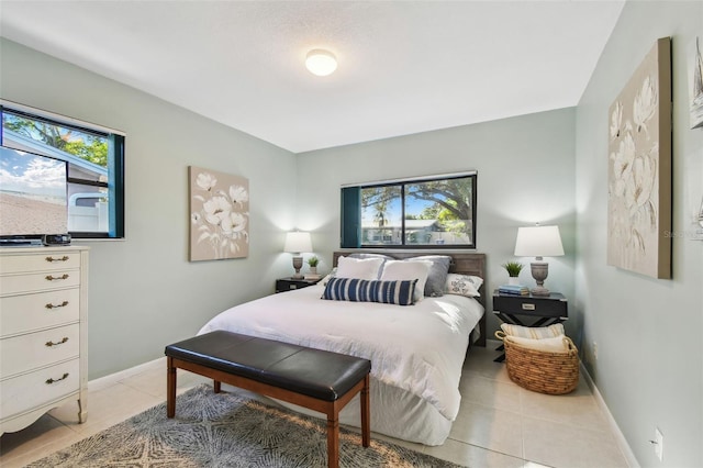 bedroom with light tile patterned floors and baseboards