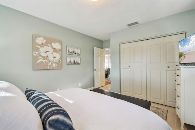 bedroom with light tile patterned floors, a closet, and visible vents