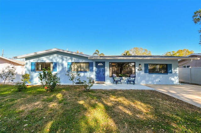 view of front of home featuring a patio, fence, and a front yard