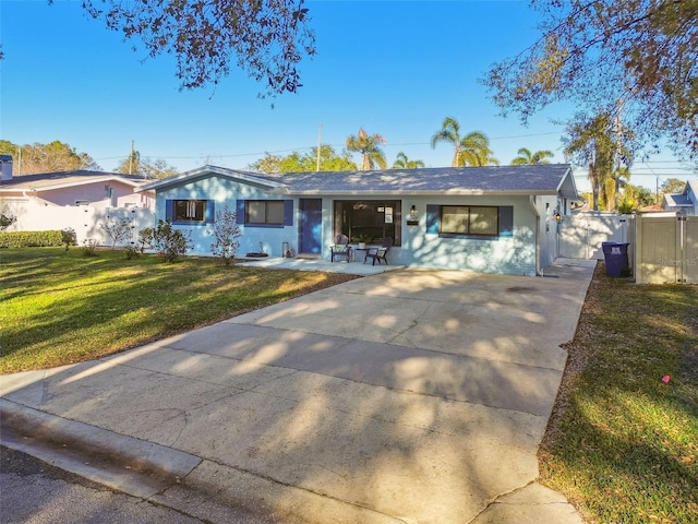 single story home featuring a front yard, concrete driveway, and fence