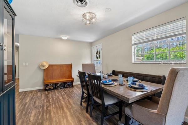 dining space with baseboards, visible vents, and wood finished floors