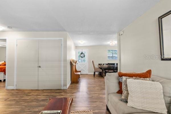 living area with baseboards and wood finished floors