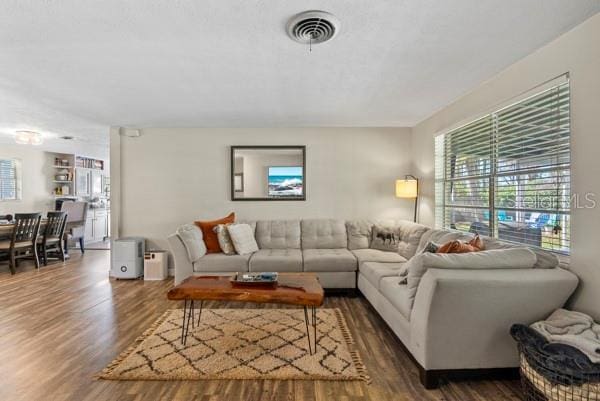 living area featuring visible vents and wood finished floors