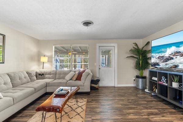 living area featuring wood finished floors, visible vents, and baseboards