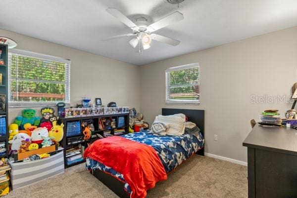 carpeted bedroom featuring a ceiling fan and baseboards