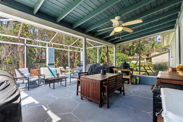 view of patio / terrace with glass enclosure, ceiling fan, and an outdoor living space