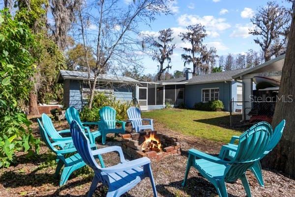 view of yard with a sunroom and a fire pit