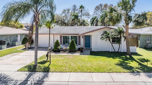 single story home with stucco siding, an attached garage, a front yard, fence, and driveway