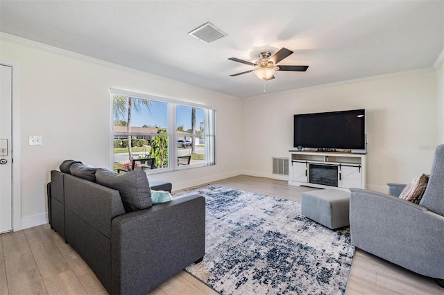 living room featuring light wood-style flooring, visible vents, and crown molding