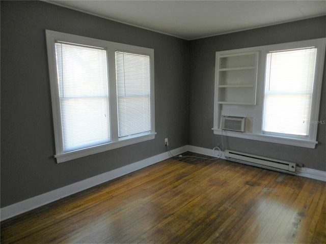 empty room featuring cooling unit, built in shelves, baseboards, a baseboard radiator, and dark wood-type flooring