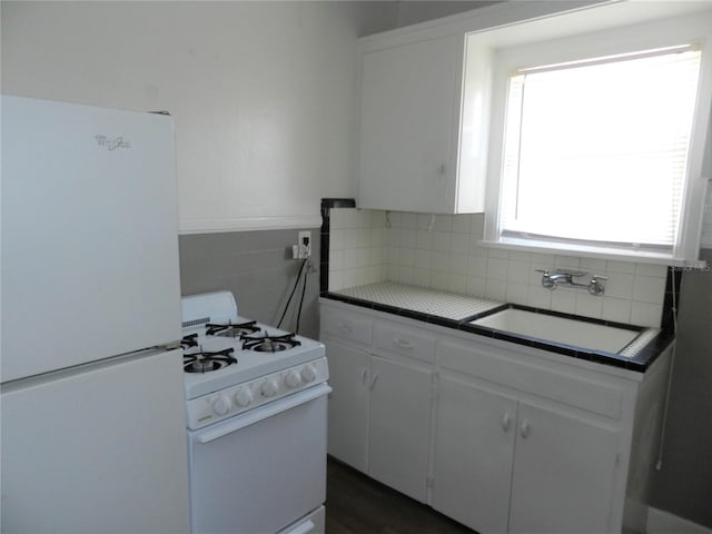 kitchen featuring a sink, white appliances, white cabinets, and tile countertops