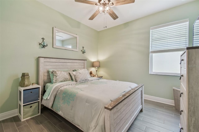 bedroom featuring baseboards, wood finish floors, and a ceiling fan