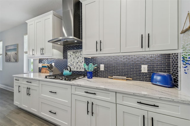 kitchen with white cabinetry, wall chimney range hood, tasteful backsplash, and stainless steel gas cooktop