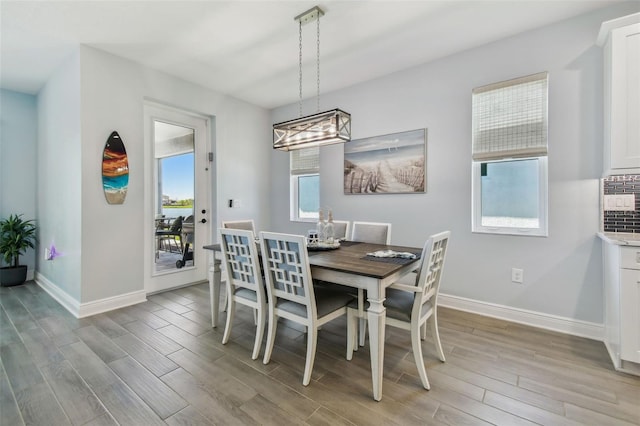 dining space with light wood finished floors and baseboards