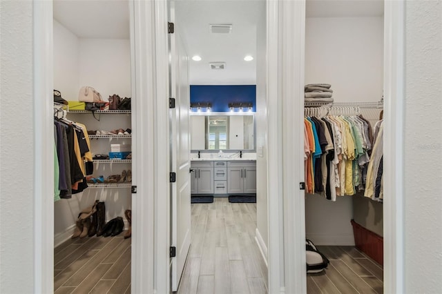 walk in closet featuring visible vents and wood finish floors