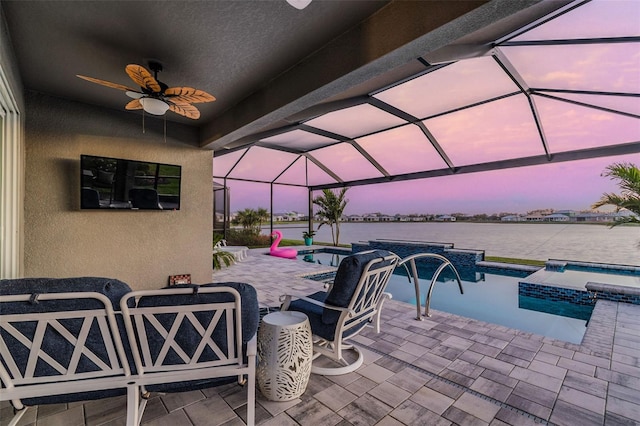 view of patio / terrace with glass enclosure, a water view, a pool with connected hot tub, and ceiling fan