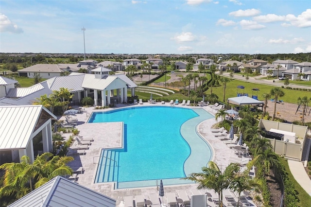 pool with a residential view, a patio, and fence