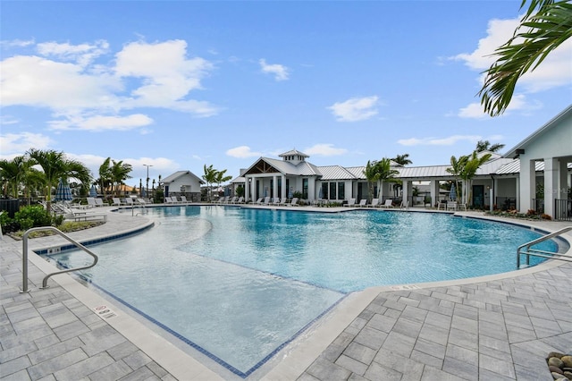 pool with a patio area and fence