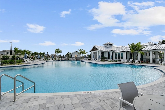 community pool with a patio area and fence