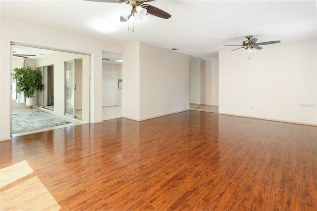 unfurnished room featuring baseboards, a ceiling fan, and wood finished floors