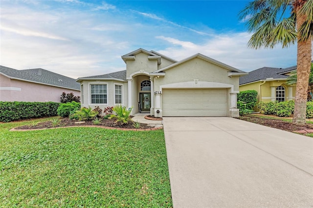 view of front facade with an attached garage, driveway, a front yard, and stucco siding