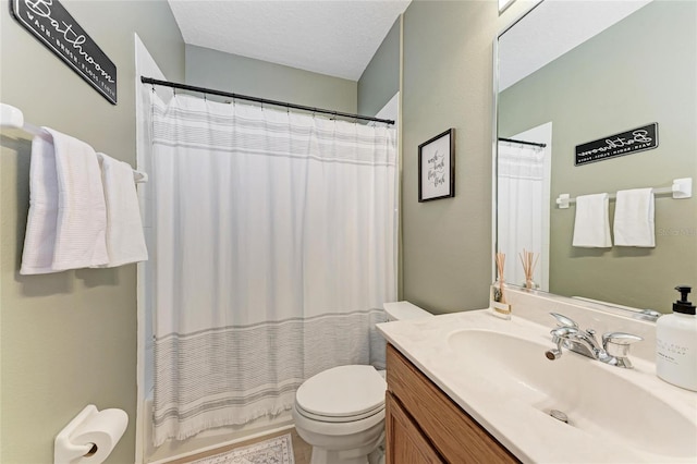 full bath featuring shower / bath combo with shower curtain, vanity, toilet, and a textured ceiling